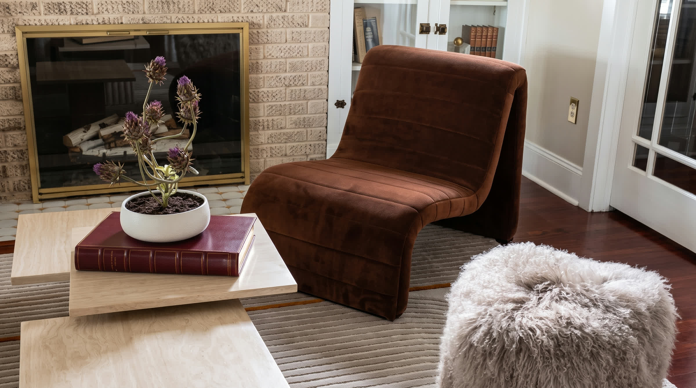 Rust velvet chair and fireplace in an original Tampa interior by Sixth Sense Studio